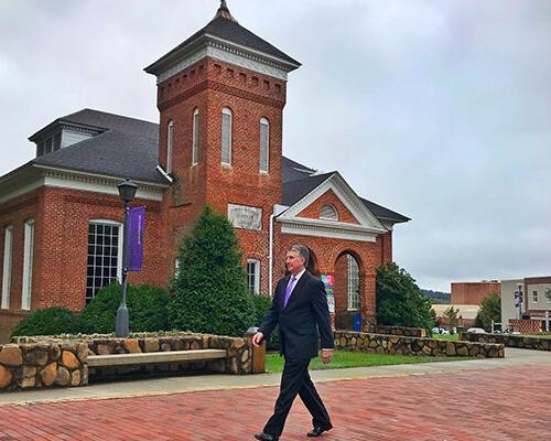 Drew Van Horn walking in front of a building